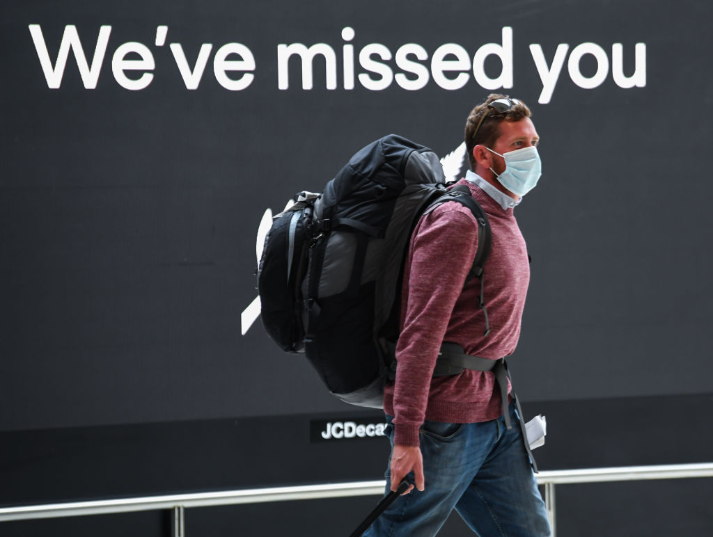 A passenger wearing a facemask walks through the airport's international arrivals area. Photo: Getty