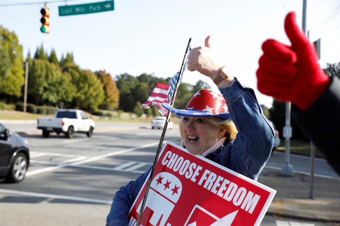 A Trump supporter holds a US flag on Election Day in Powder Springs, Georgia. Photo: Reuters