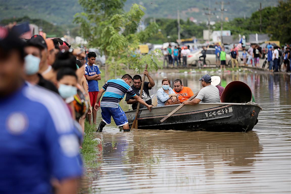 People take to boats in floodwaters during the passage of Storm Eta, in Pimienta, Honduras. Photo...