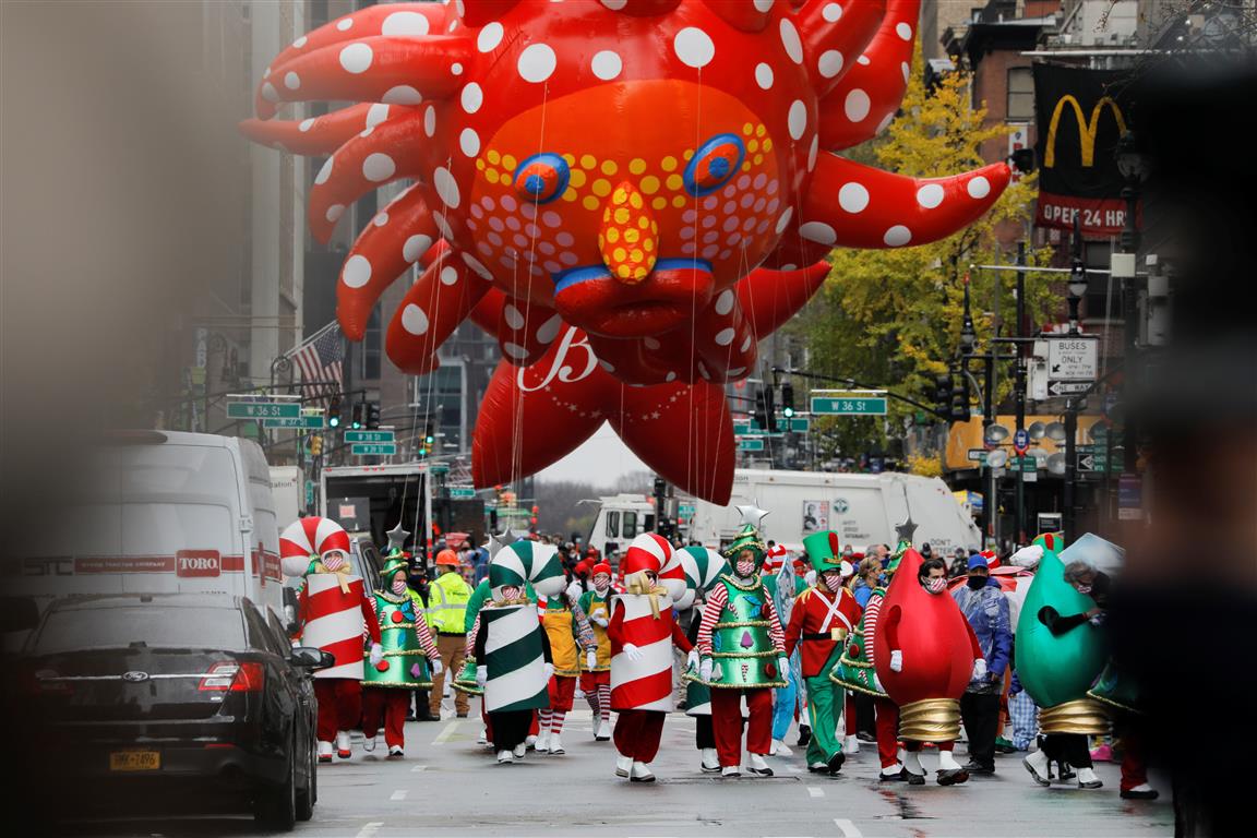 Assistants carry Yayoi Kusama's "Love Flies Up to the Sky" balloon during the 94th Macy's...