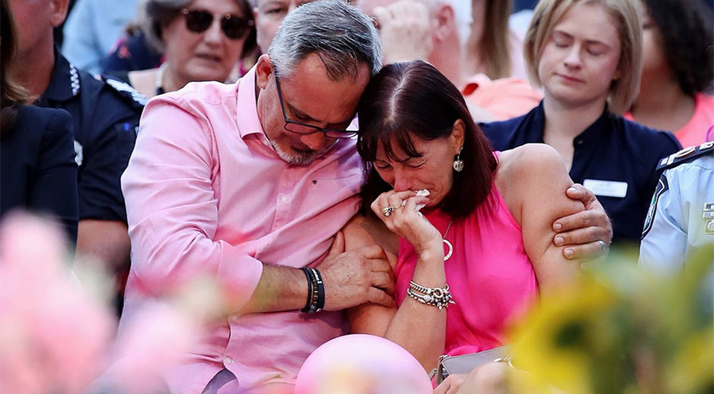 Lloyd and Suzanne Clarke embrace at a vigil for their daughter Hannah and her three children....