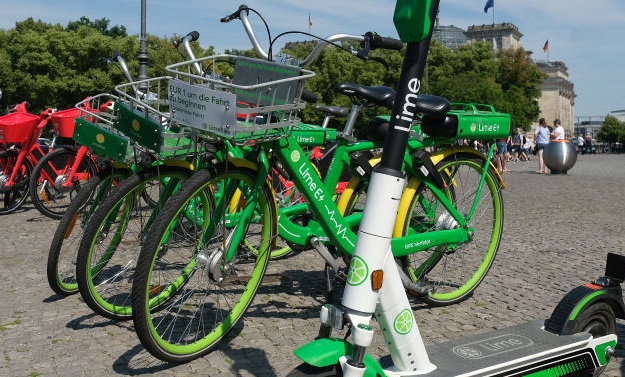 An electric scooter from bike and scooter sharing company Lime stands near sharing bicycles. Photo: Getty Images