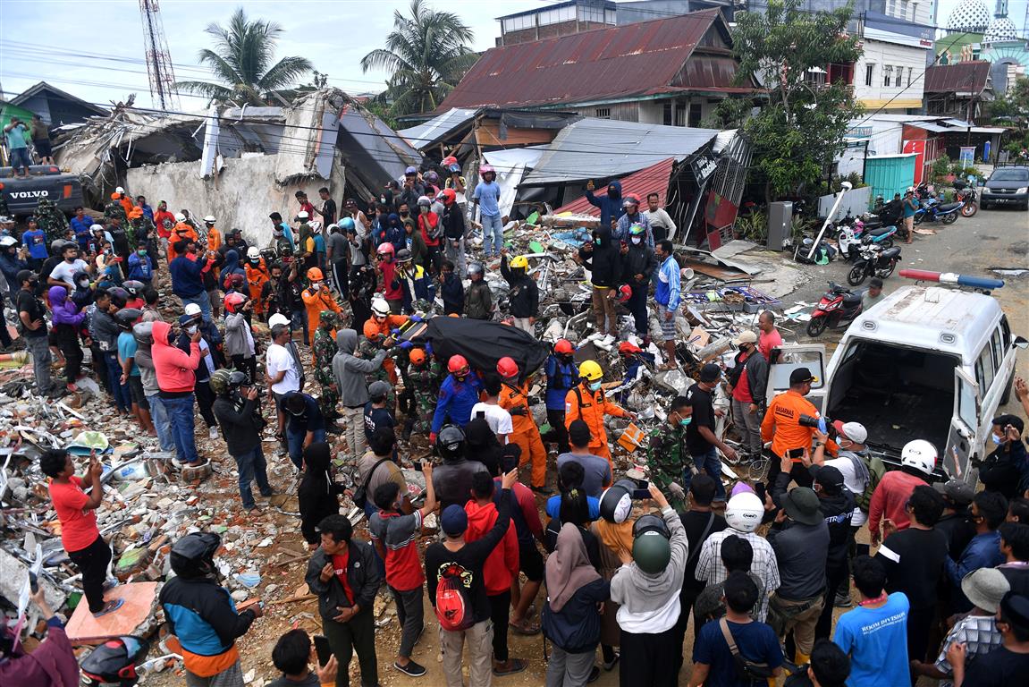 Rescue workers carry a body containing an earthquake victim. Photo: Foto/Sigid Kurniawan/ via...