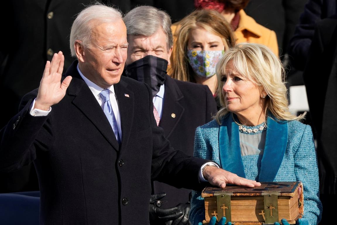 Joe Biden is sworn in as the 46th president of the United States as Jill Biden holds the Bible...