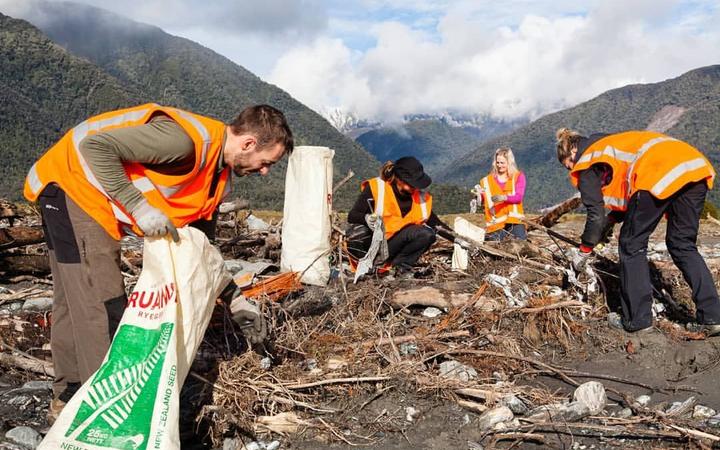 Cleaners picking up rubbish that spilled out of the old Fox landfill. Photo: Owen Kilgour via RNZ