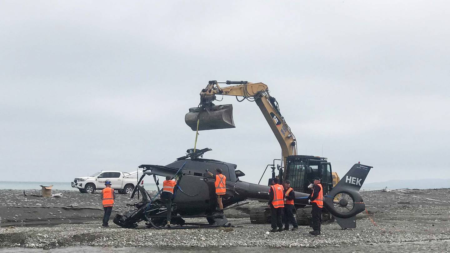 The wreckage of the helicopter is removed from Kēkerengū Beach. Photo: NZ Herald

