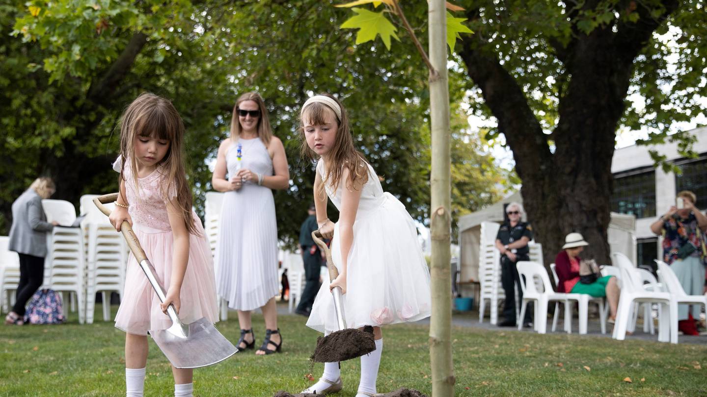 Breanna Gowland watching her daughters plant a memorial tree in Christchurch yesterday. Photo:...