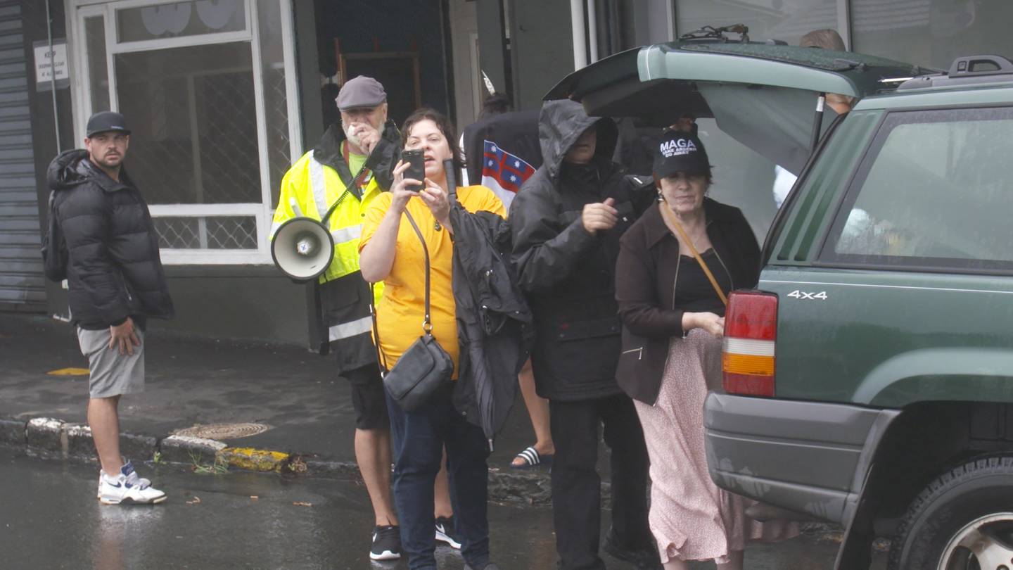 Anti-lockdown protestors gather outside Prime Minister Jacinda Ardern's vacant electorate office...