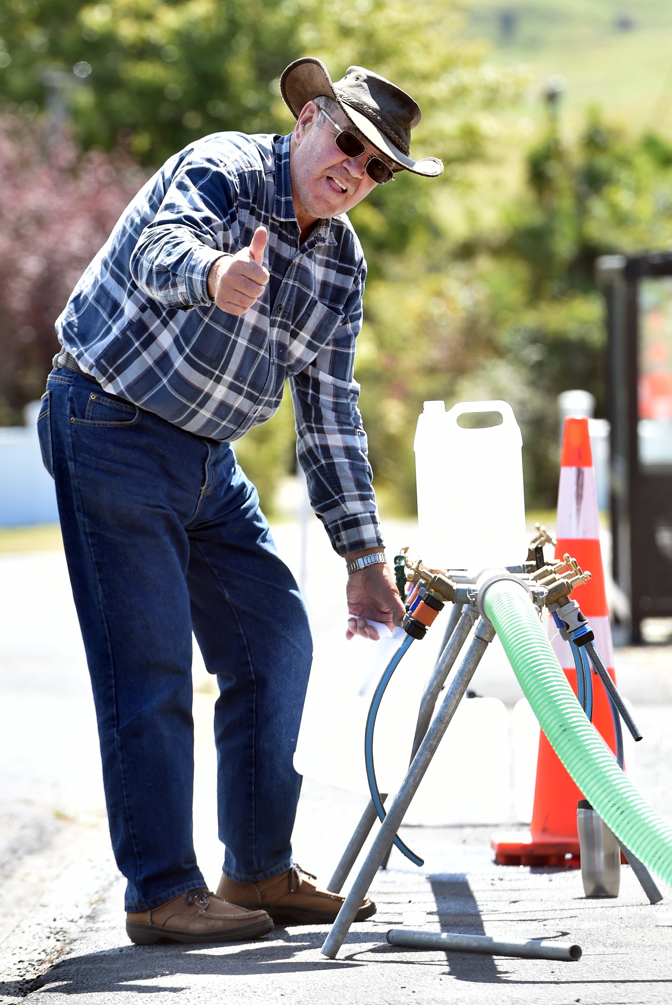 Bruce Hayward, of Waikouaiti, fills a carton with water from a tanker yesterday after getting his...