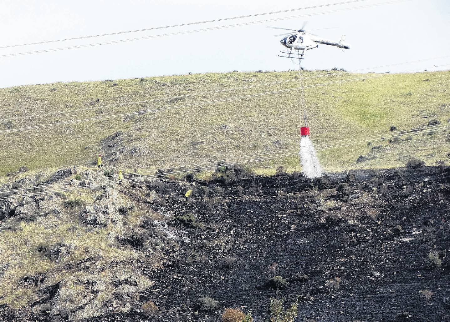 A helicopter is used to help fight a fire above the Lake Waitaki dam village yesterday. PHOTO:...