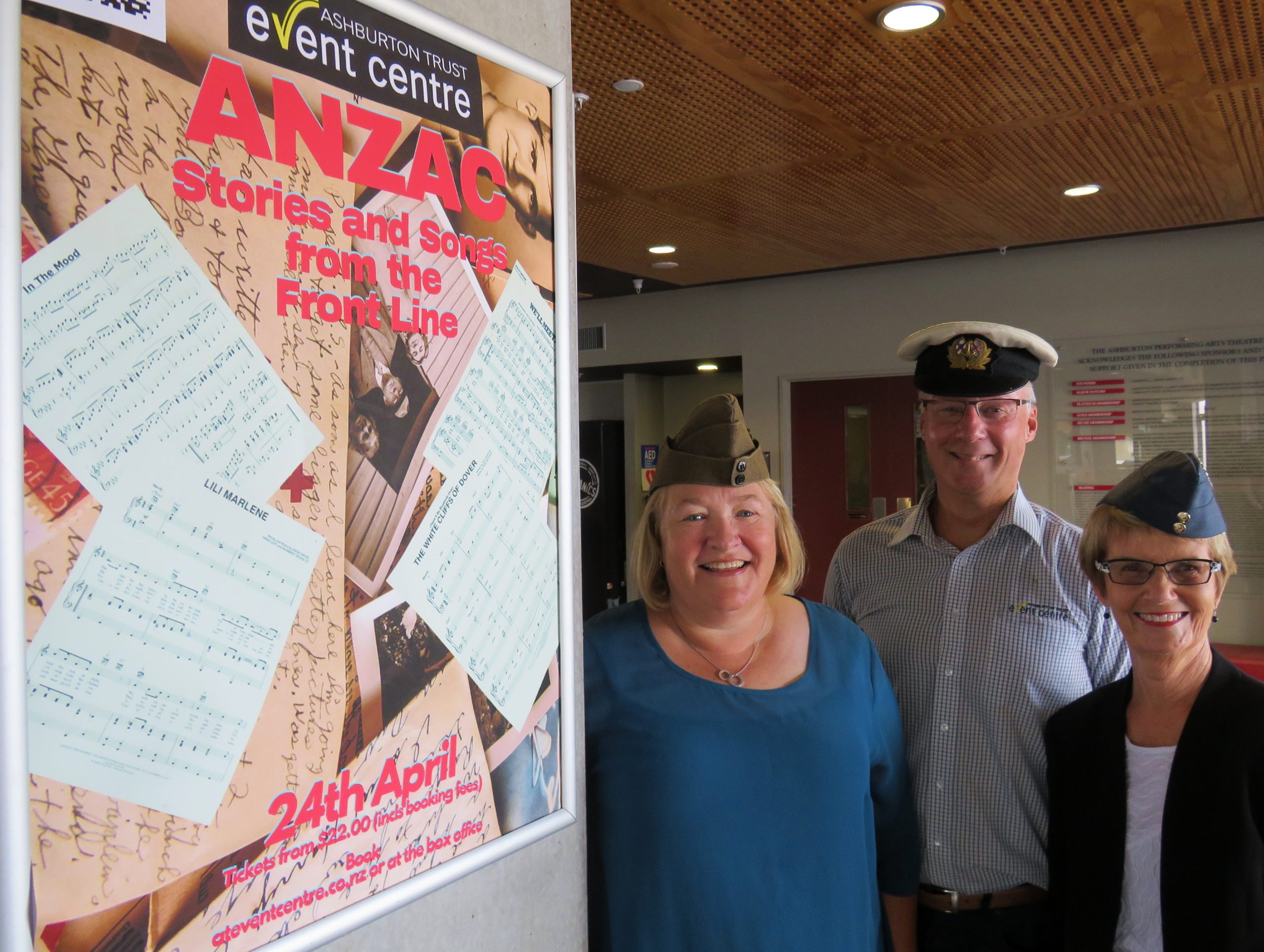 Wearing military hats and standing to attention are show compilers (from left) Sally Farr, Roger...