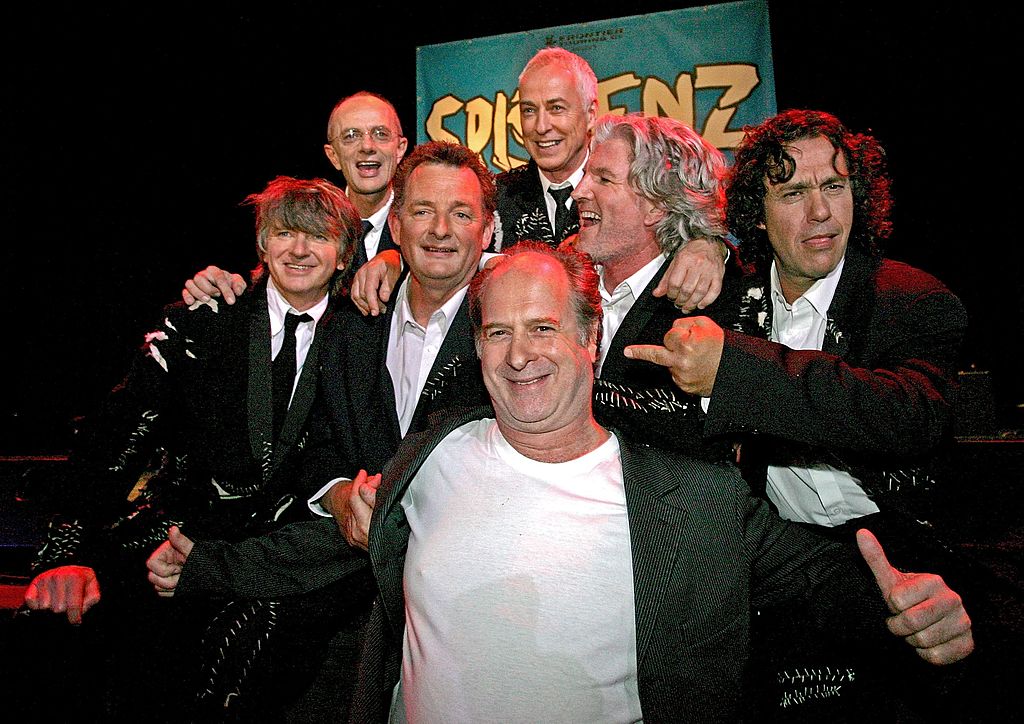 Michael Gudinski (c) poses with Split Enz during a press conference in Melbourne in February 2006...