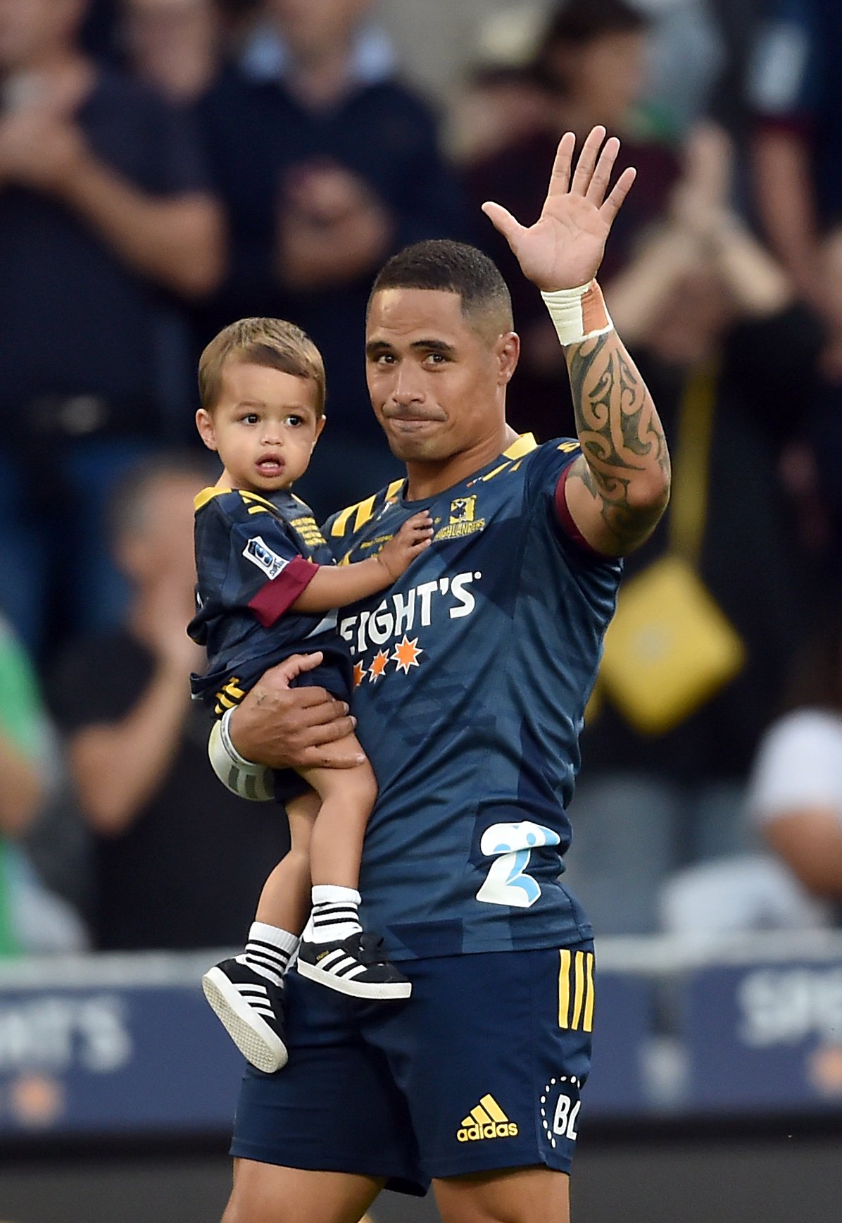 Aaron Smith, with son Luka, acknowledges the crowd at Forsyth Barr Stadium last night before...