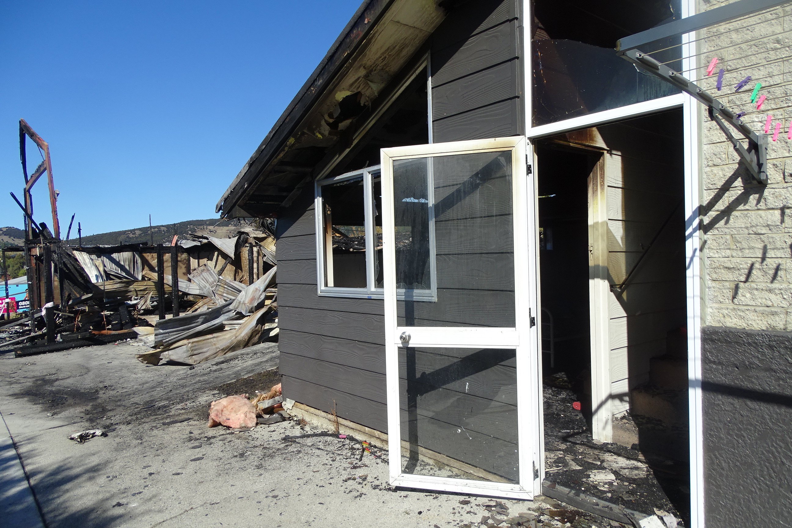 One house on a Wanaka property, pictured in the foreground, was badly damaged while the other, in...