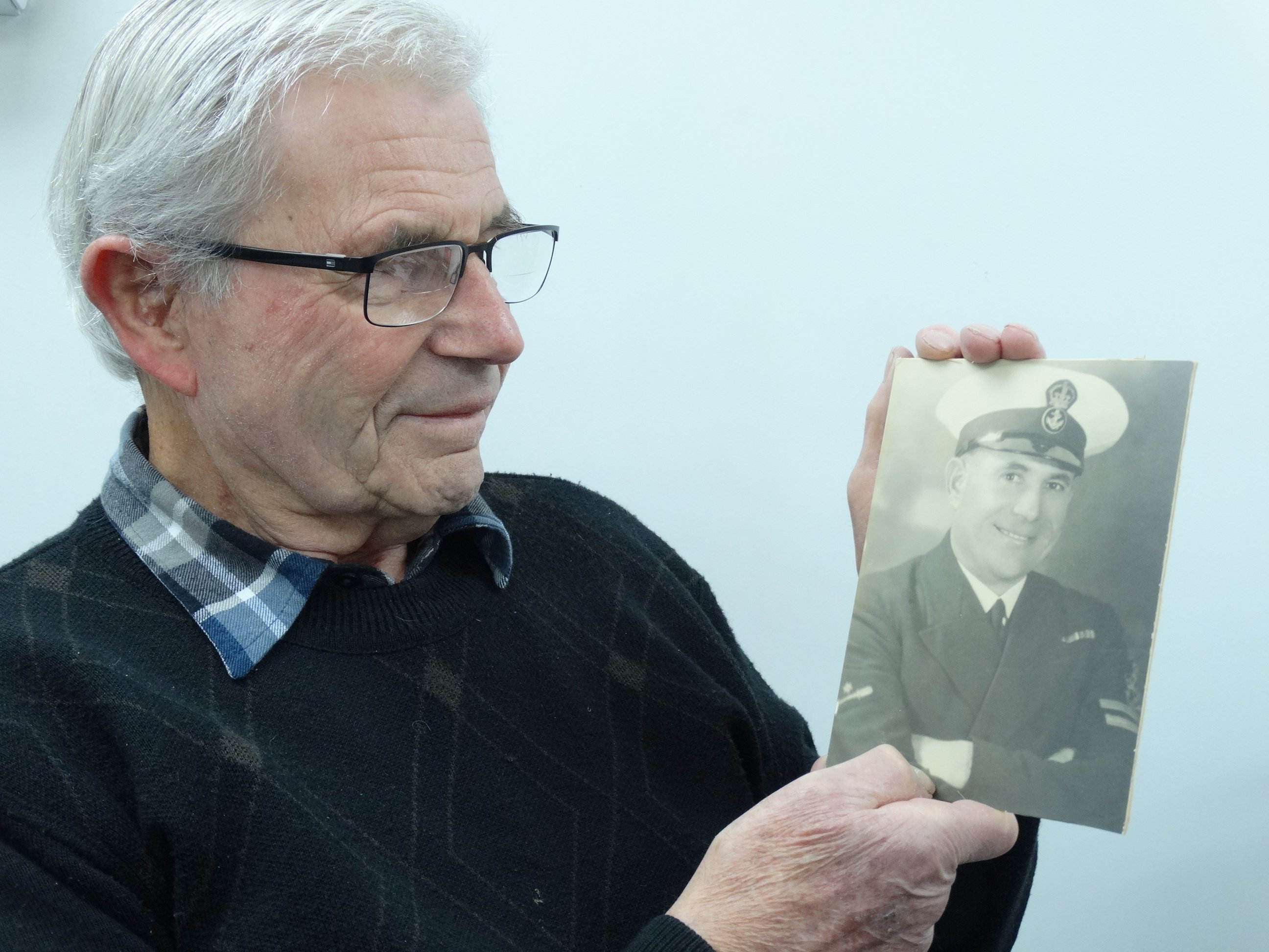 Bob Britton holds a portrait of his father, Bill, who rescued Prince Philip from Corfu in 1922....
