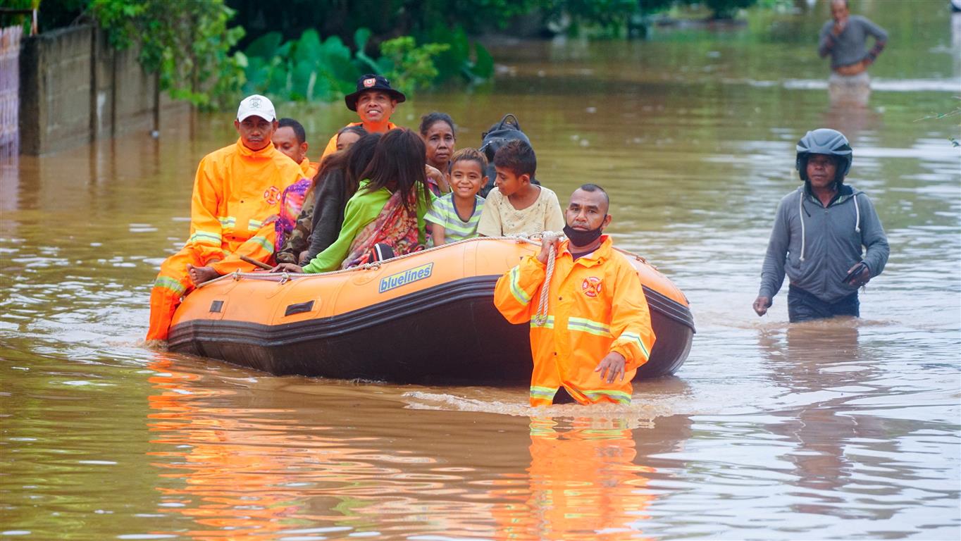 Rescue workers evacuate people in an area affected by floods in Dili, East Timor, at the weekend....