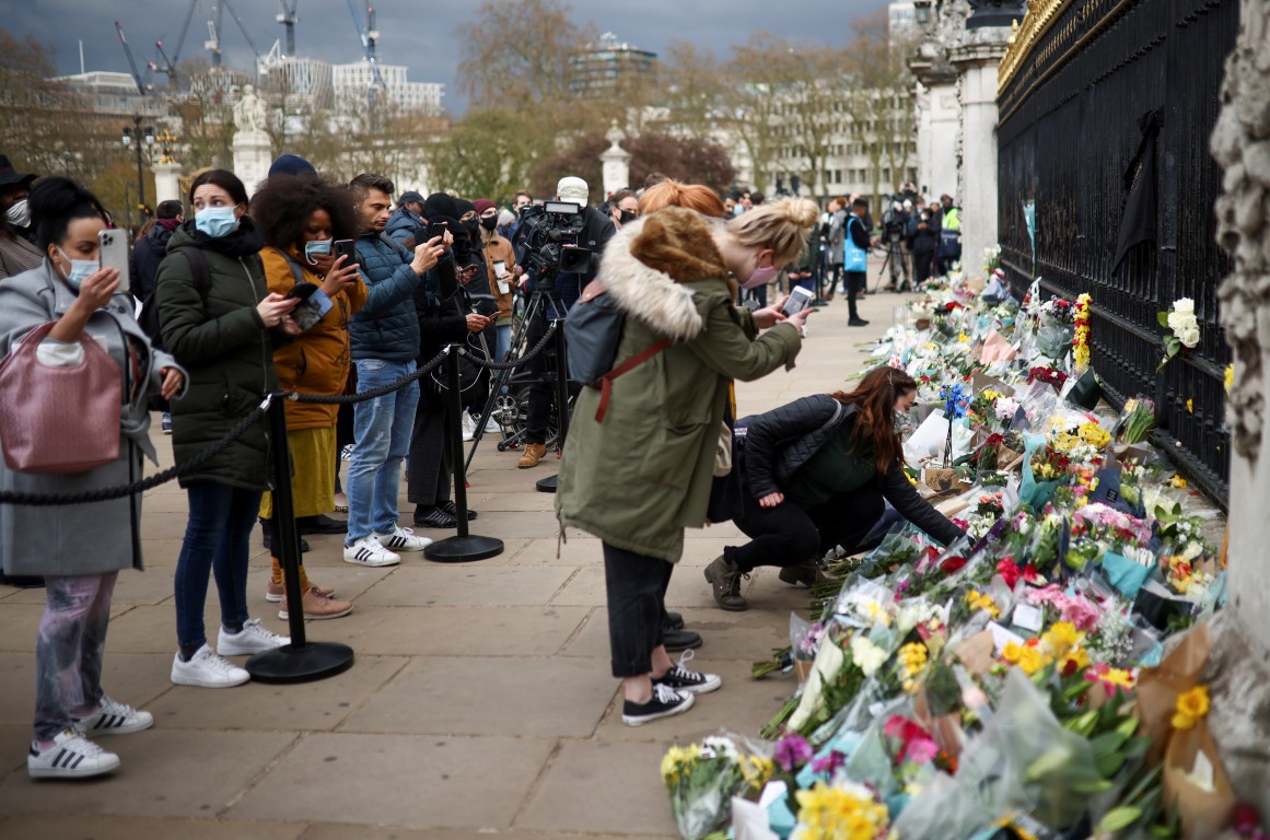 People leave floral tributes outside Buckingham Palace in London following the death of Prince...