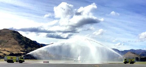 The plane makes its way under the water arch on arrival to Queenstown Airport. Photo: RNZ