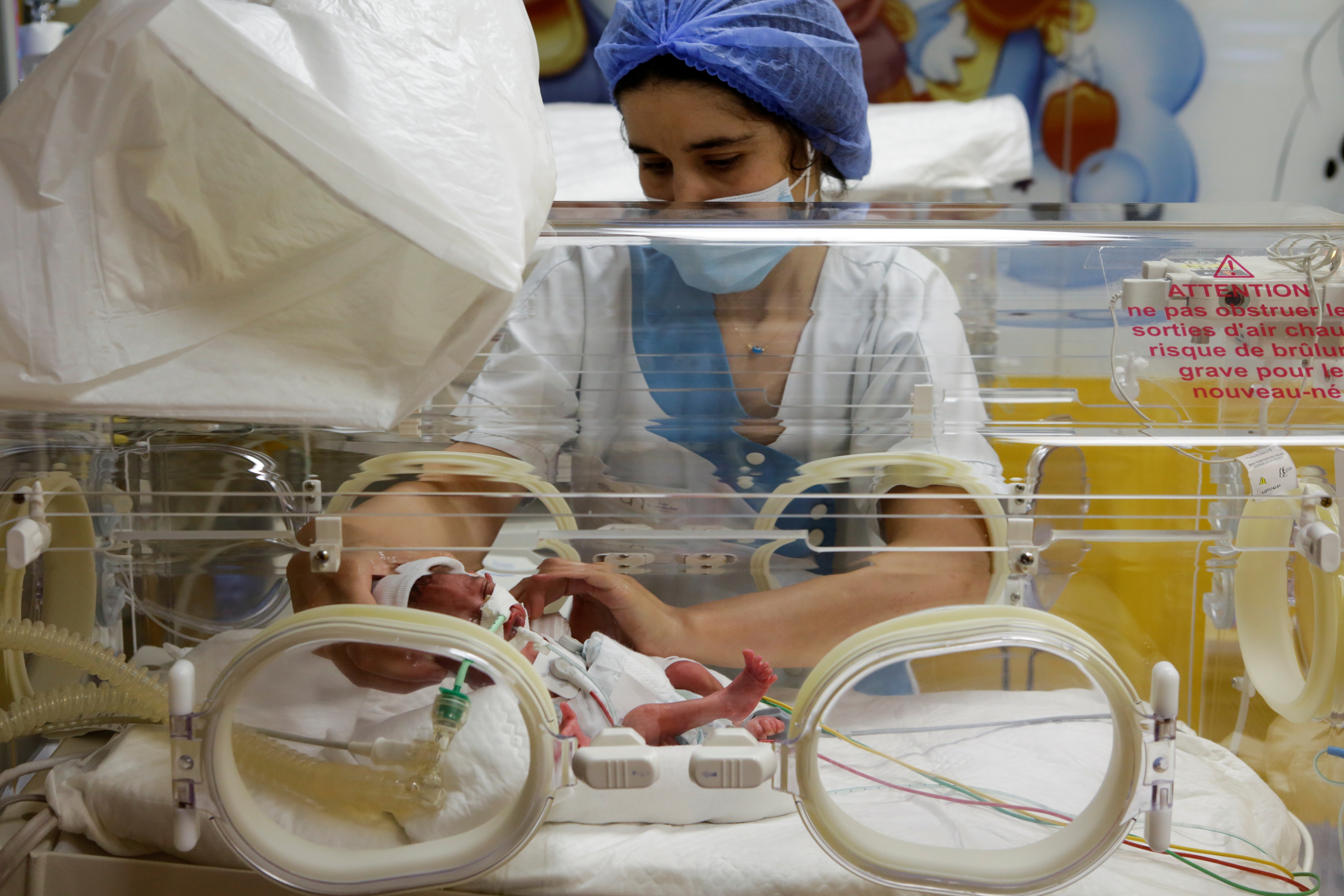 A nurse takes care of one of the nonuplets lying in an incubator at a private clinic in...