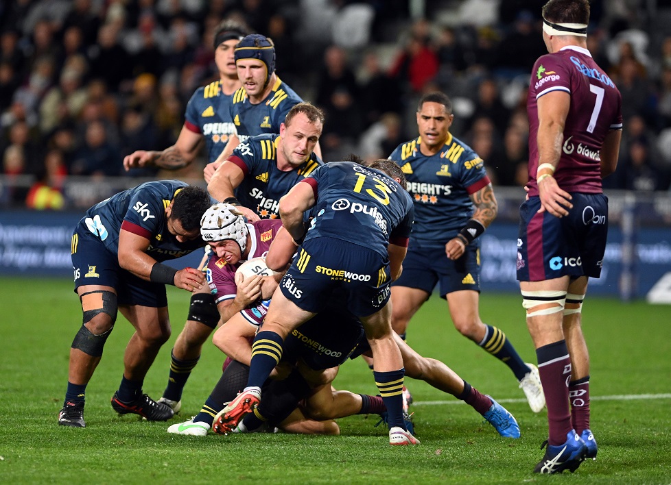 Reds midfielder Hamish Stewart is swamped by Highlanders players. Photo: Linda Robertson