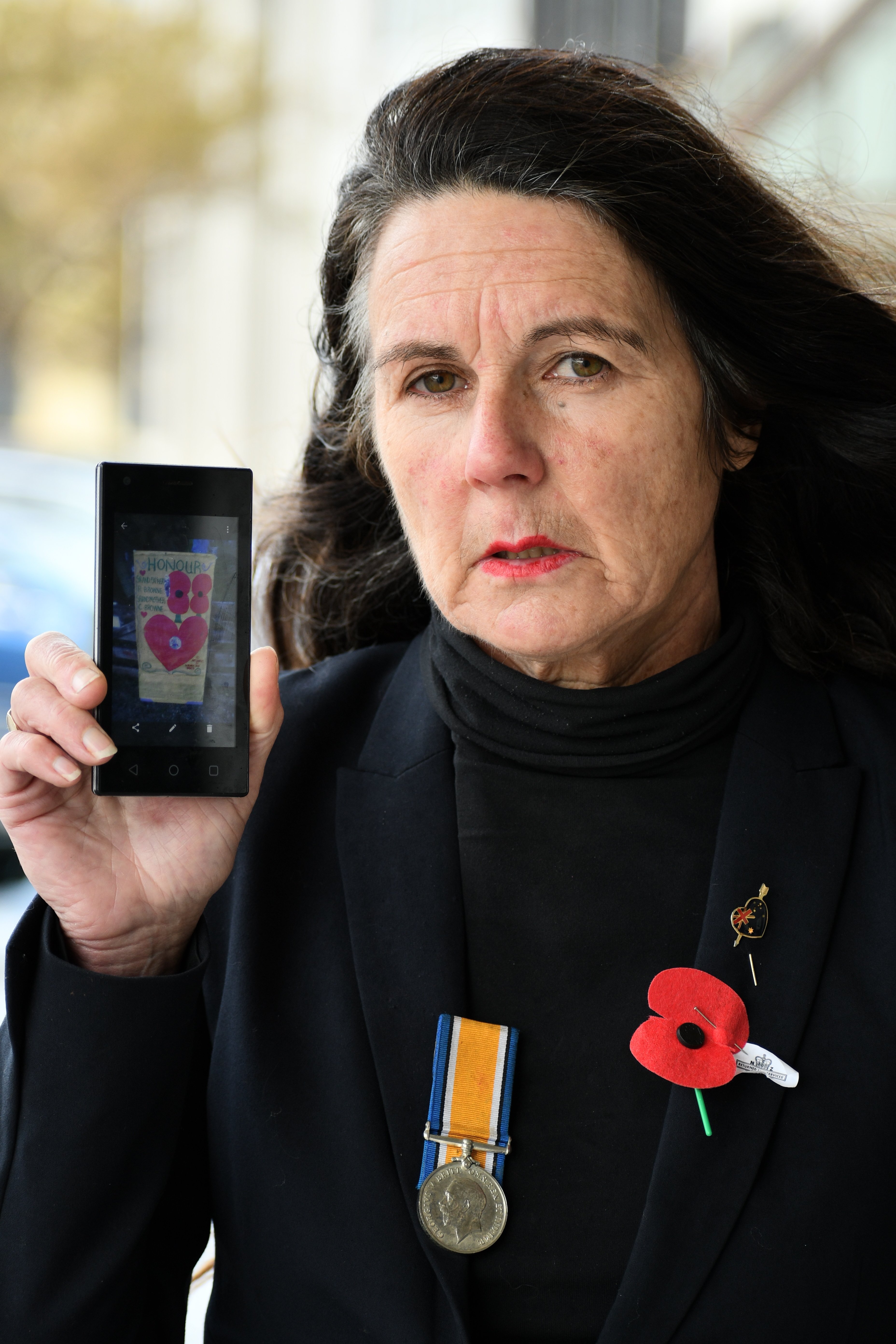 Nightcaps resident Wendy Baker’s Anzac painting (shown here on her phone) has been torn from her...