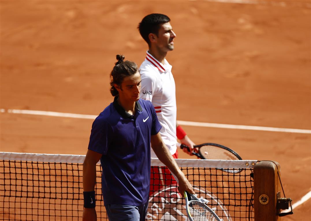 Lorenzo Musetti (L) and Novak Djokovic walk off the court after Musetti retired injured. Photo:...