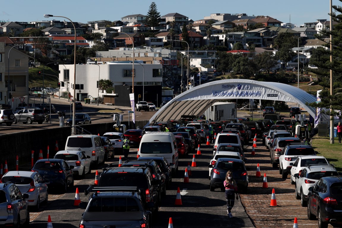 Vehicles wait in line at the Bondi Beach drive-through Covid-19 testing centre in Sydney as...