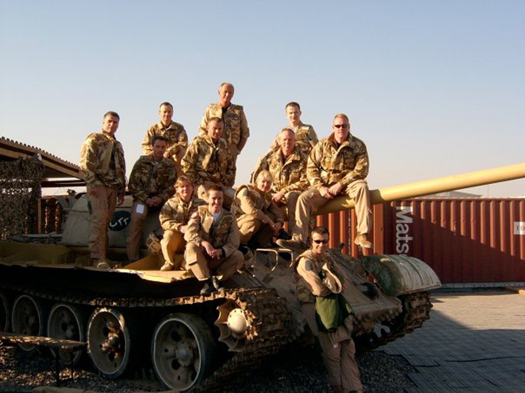 Shelley Charlton with her former RAF colleagues sitting on a non-functioning tank in Basra, Iraq.