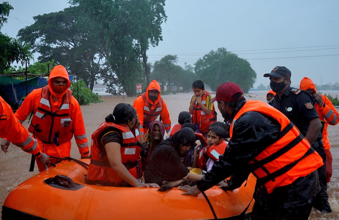 Rescue workers evacuate people from a flooded area in Kolhapur in the western state of...