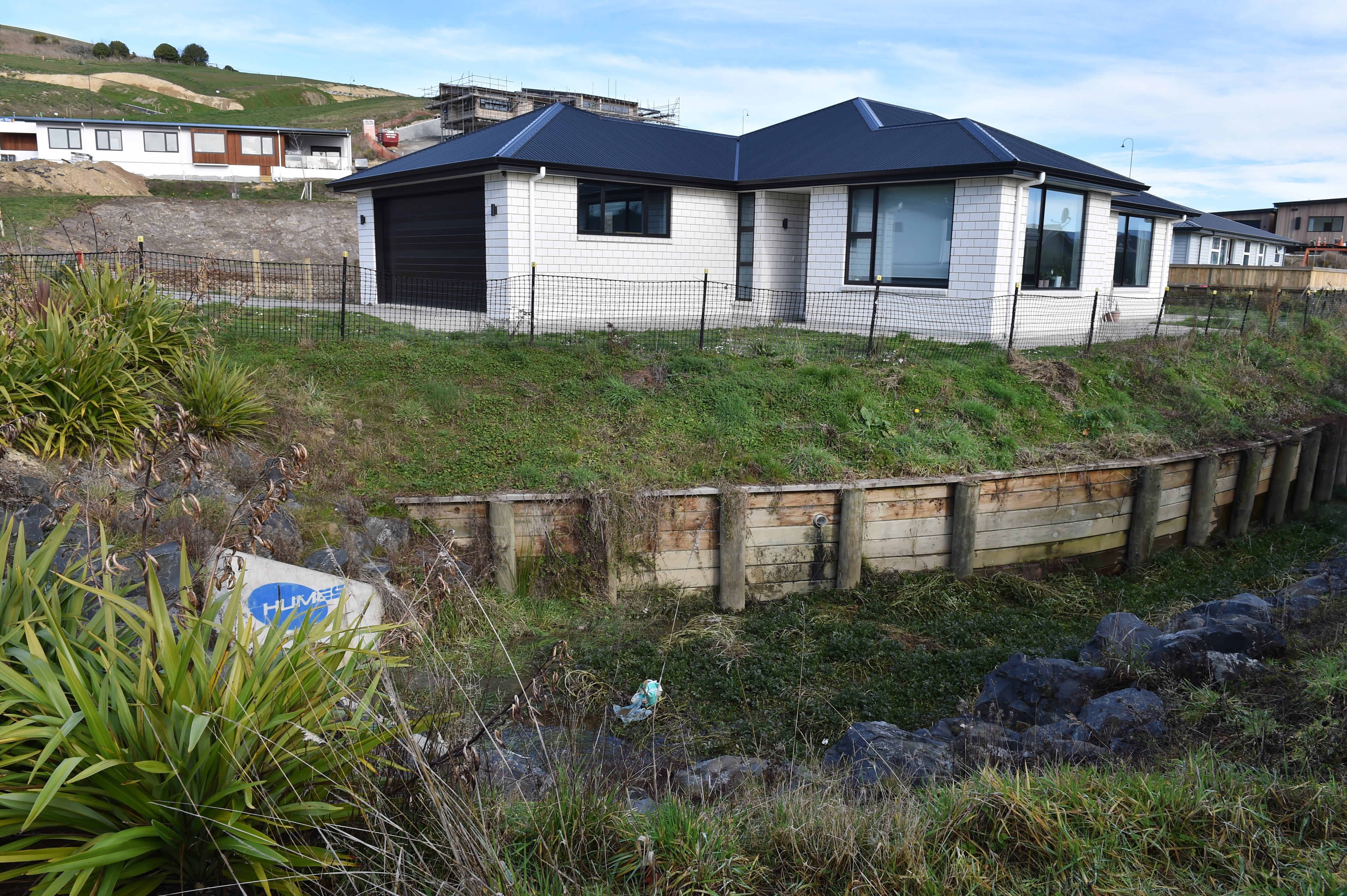 The owners of this Mosgiel home have been told to fix a retaining wall on their property or face...