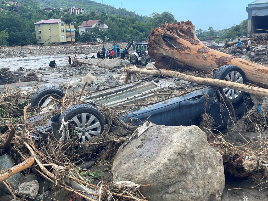 A vehicle lies amid debris after a flash flood swept through in the town of Bozkurt in the...