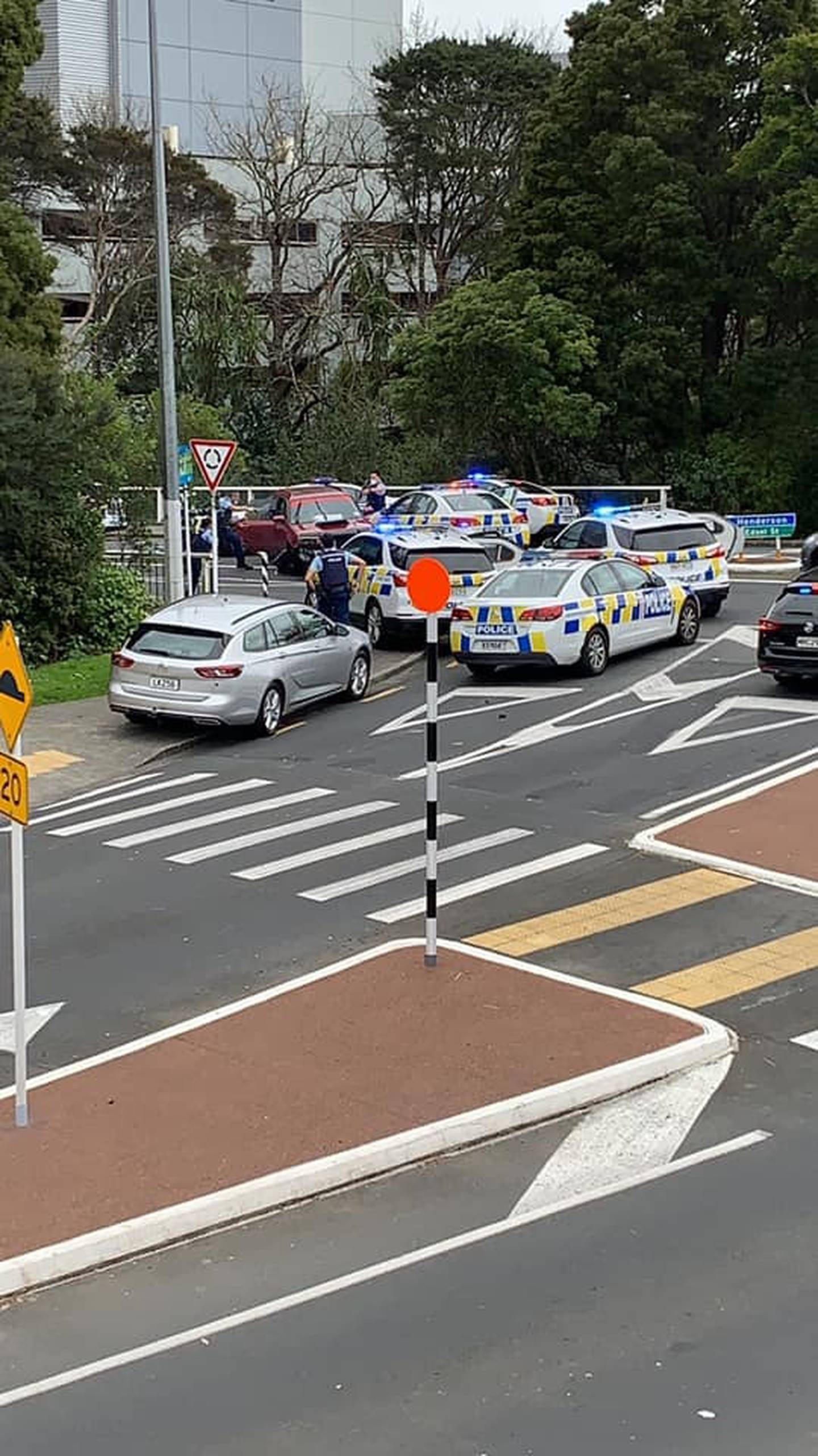 Police swarm a car after a pursuit through West Auckland today. Photo / Drew Kelly via NZ Herald
