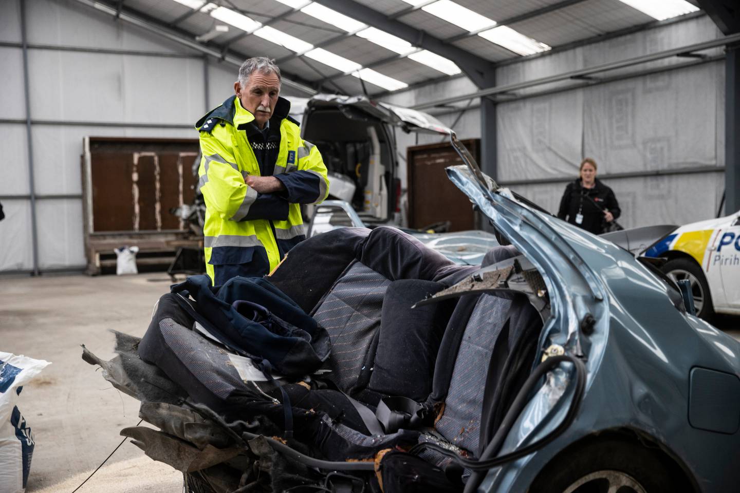 Inspector Dave Gaskin looks over the car, which was ripped in half by the impact. Photo: NZ Herald