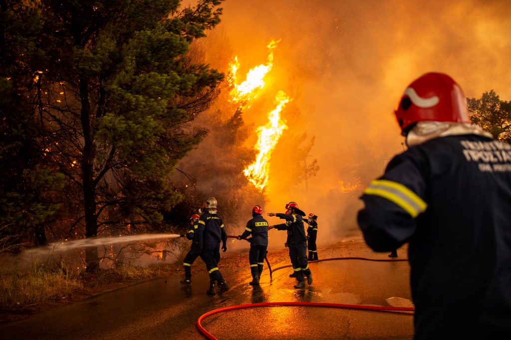 Crews battle a forest fire approaching a gas station in a wooded area north of Athens. Photo: Getty