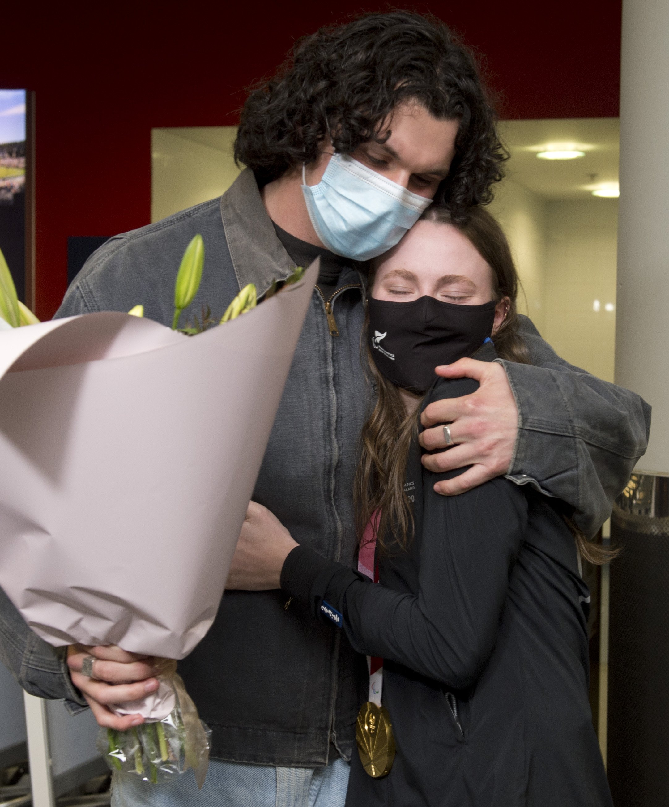 Long jump gold medallist Anna Grimaldi is greeted home by partner Felix McDonald at the airport...