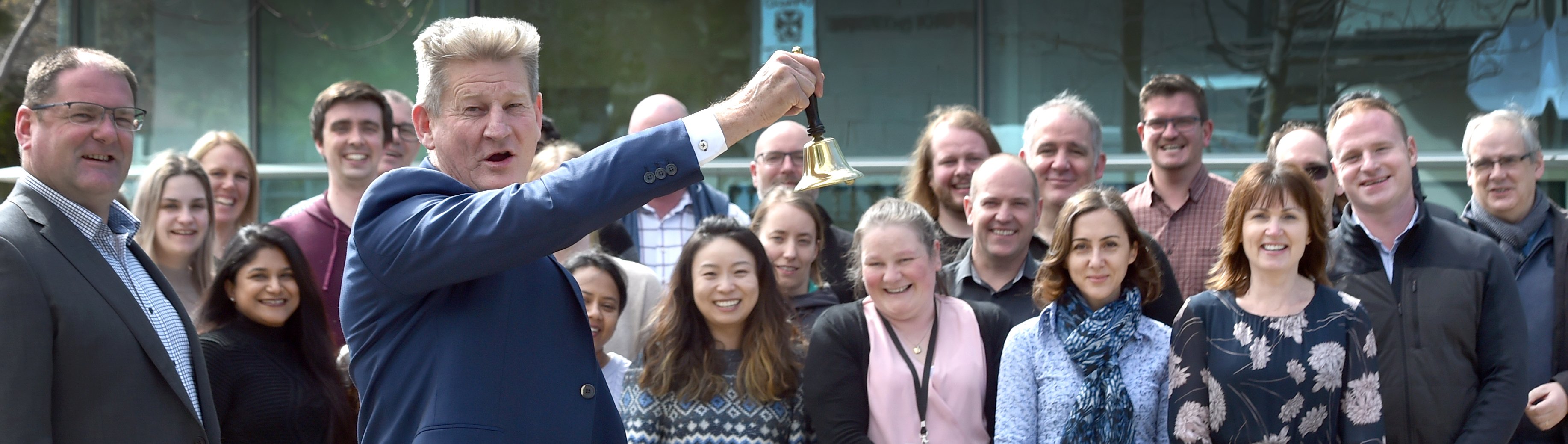 Pacific Edge chief executive David Darling rings a bell, watched by staff, in celebration of the...