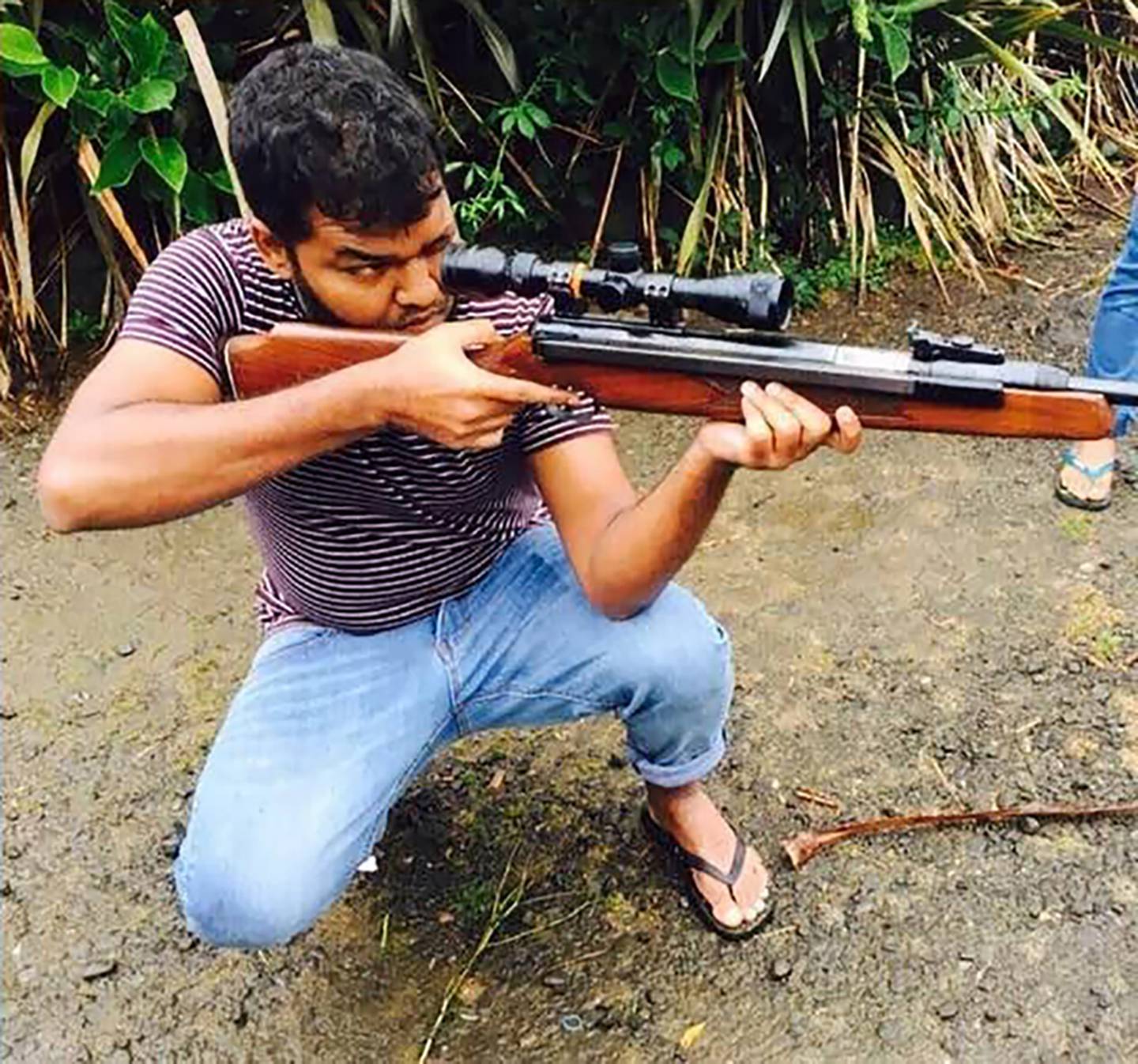 Ahamed Aathil Mohamed Samsudeen pictured taking aim with a firearm in a photo from one of his...