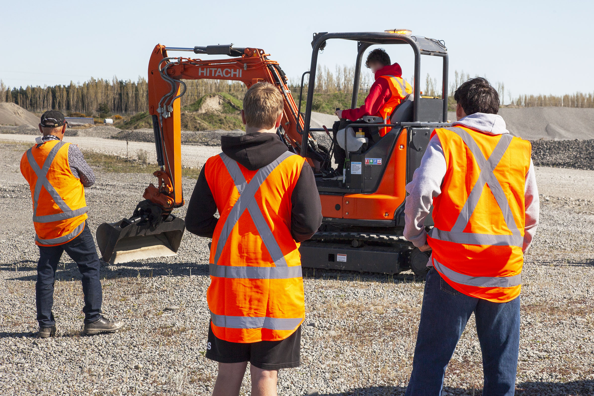Paul Coulter shows one of the students how to use of an excavator. Photo: Geoff Sloan