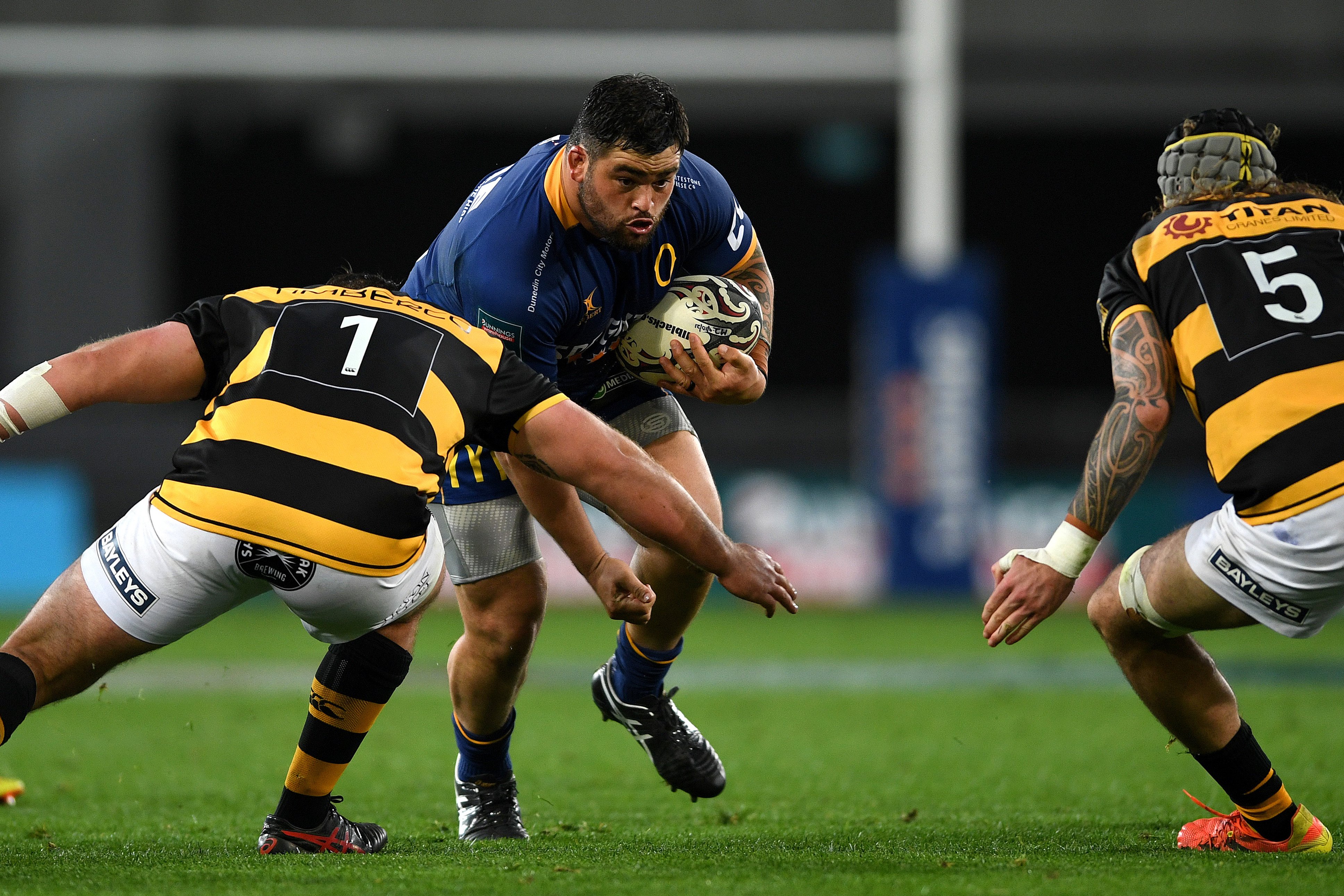 Otago prop Jermaine Ainsley runs at Taranaki defenders Reuben O’Neill (left) and Fin Hoeata at...