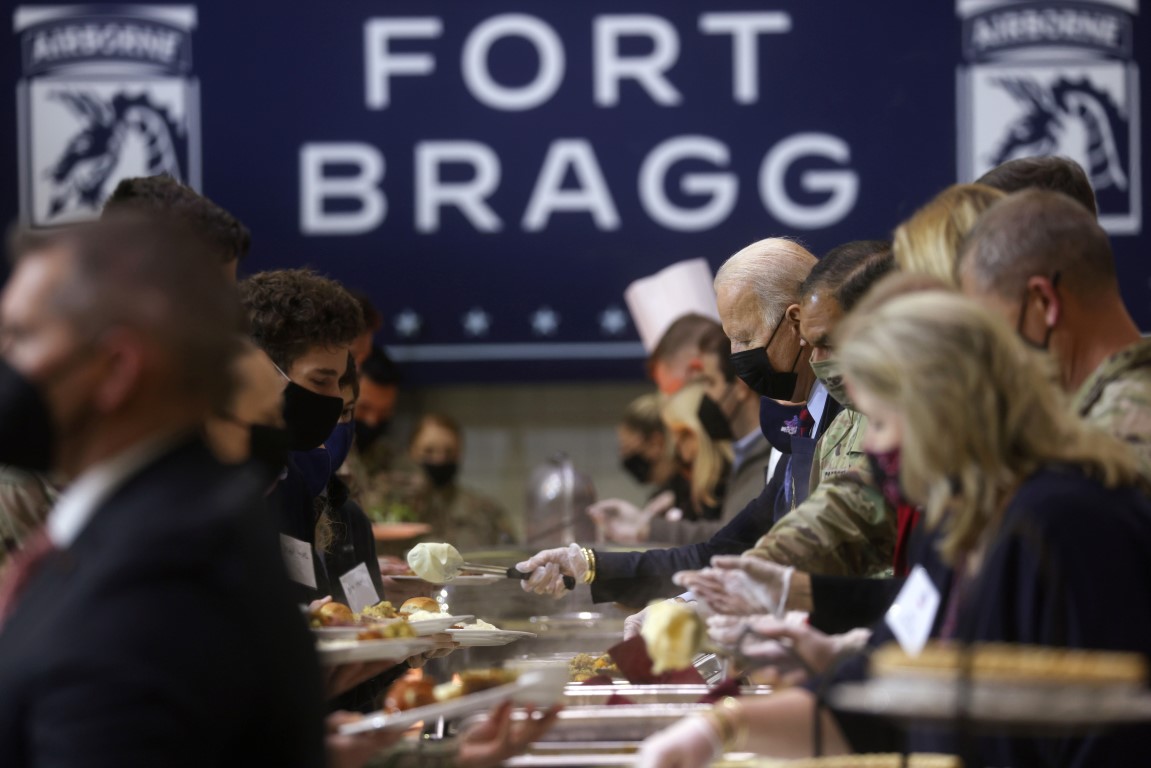 President Joe Biden serves food during a Thanksgiving event with US service members and military...