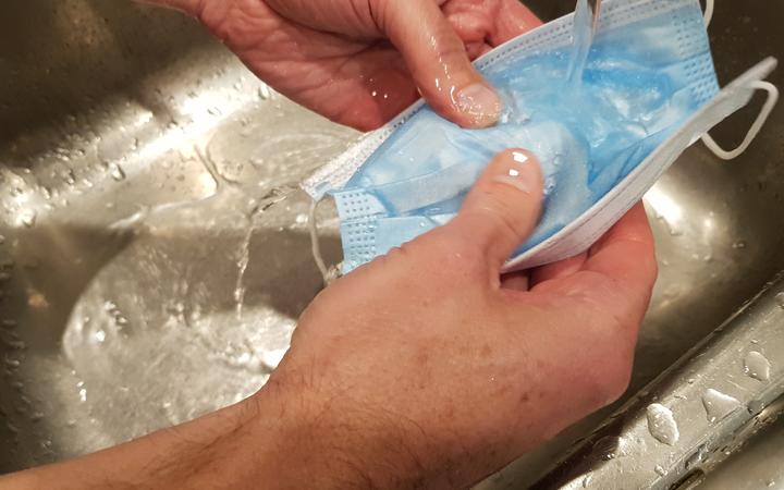 Microbiologist Richard Everts washes a disposable mask in warm water. Photo: Supplied