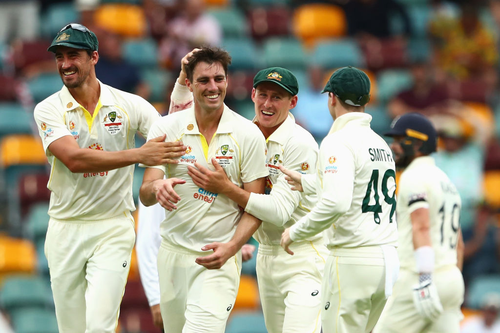 Australia's Pat Cummins celebrates with teammates after dismissing England's Chris Woakes. Photo:...