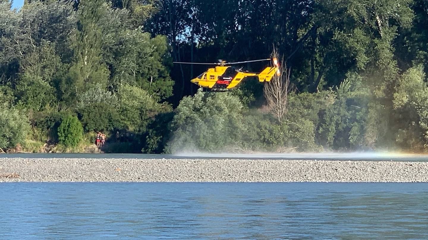 A helicopter hovers over the Waimakariri River in Canterbury after a swimmer disappeared on...