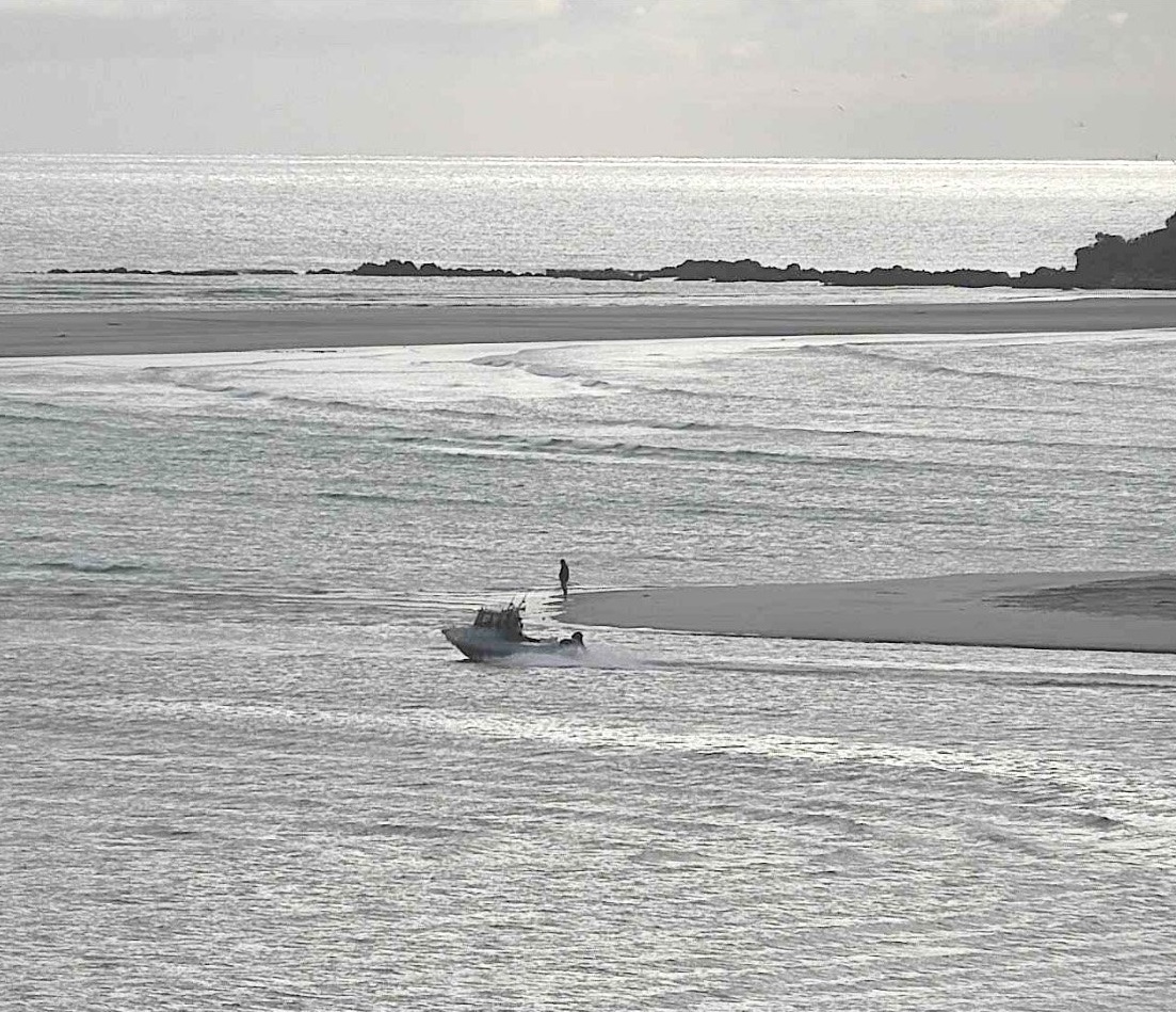 An outgoing fishing boat navigates the channel at Taieri Mouth as seen by the live update camera...