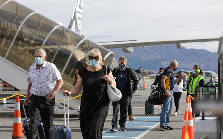 Passengers arriving in Queenstown on the first flight from Auckland in December after border...