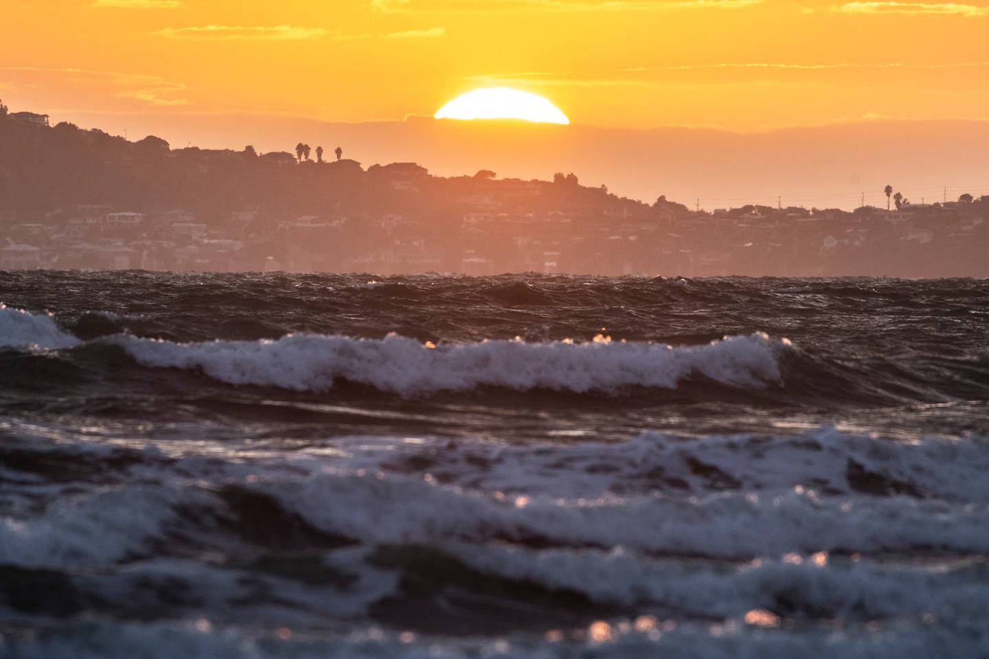 The sun rises at Auckland's Orewa Beach. Photo / Michael Craig