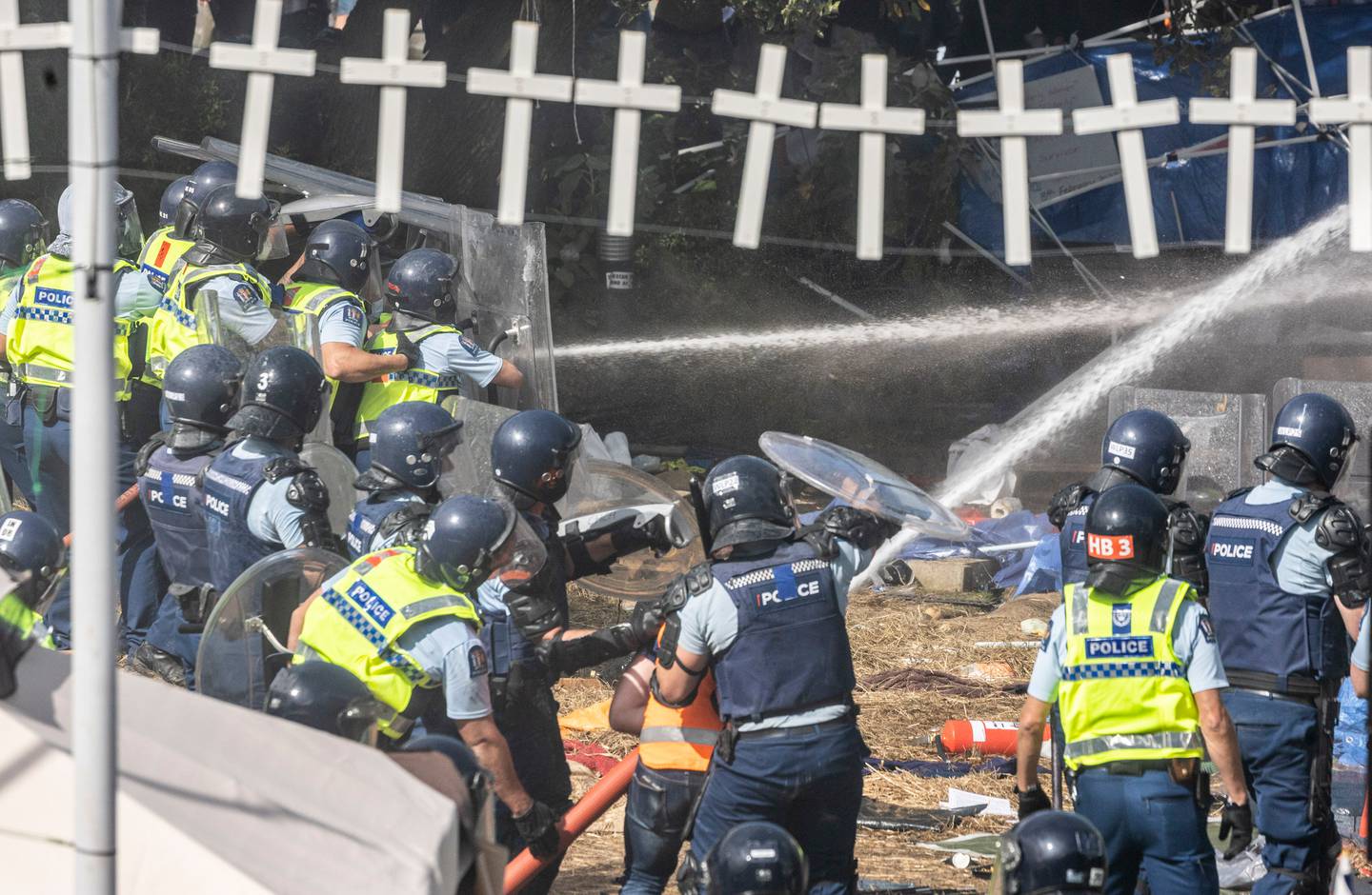 Police help to put out one of the blazes at the protest in Wellington yesterday. Photo: Mike Scott