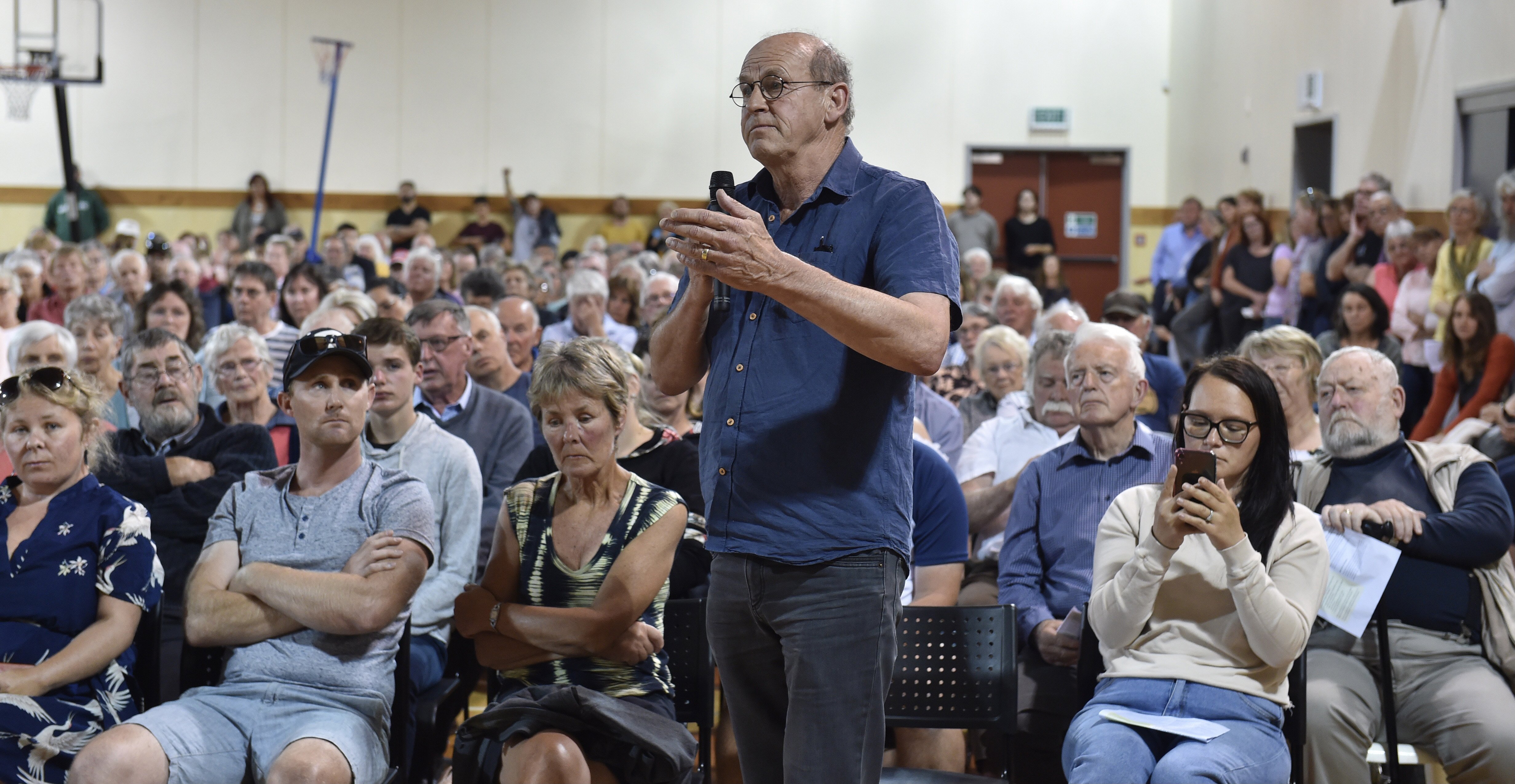 Alex McAlpine puts questions to local government representatives during a public meeting to...
