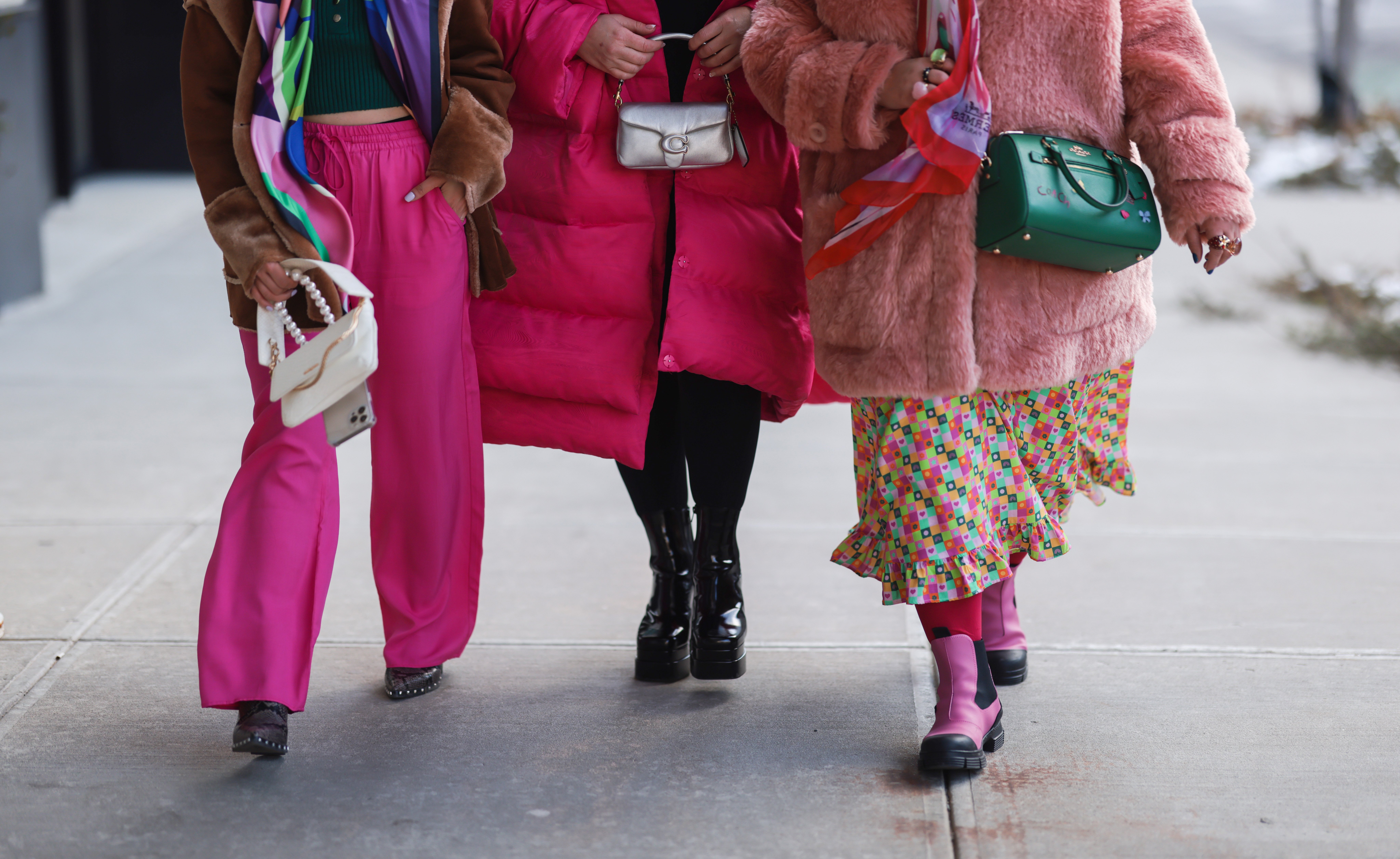 Vibrant pinks and reds are co-ordinated among friends in voluminous oversized layers at New York...