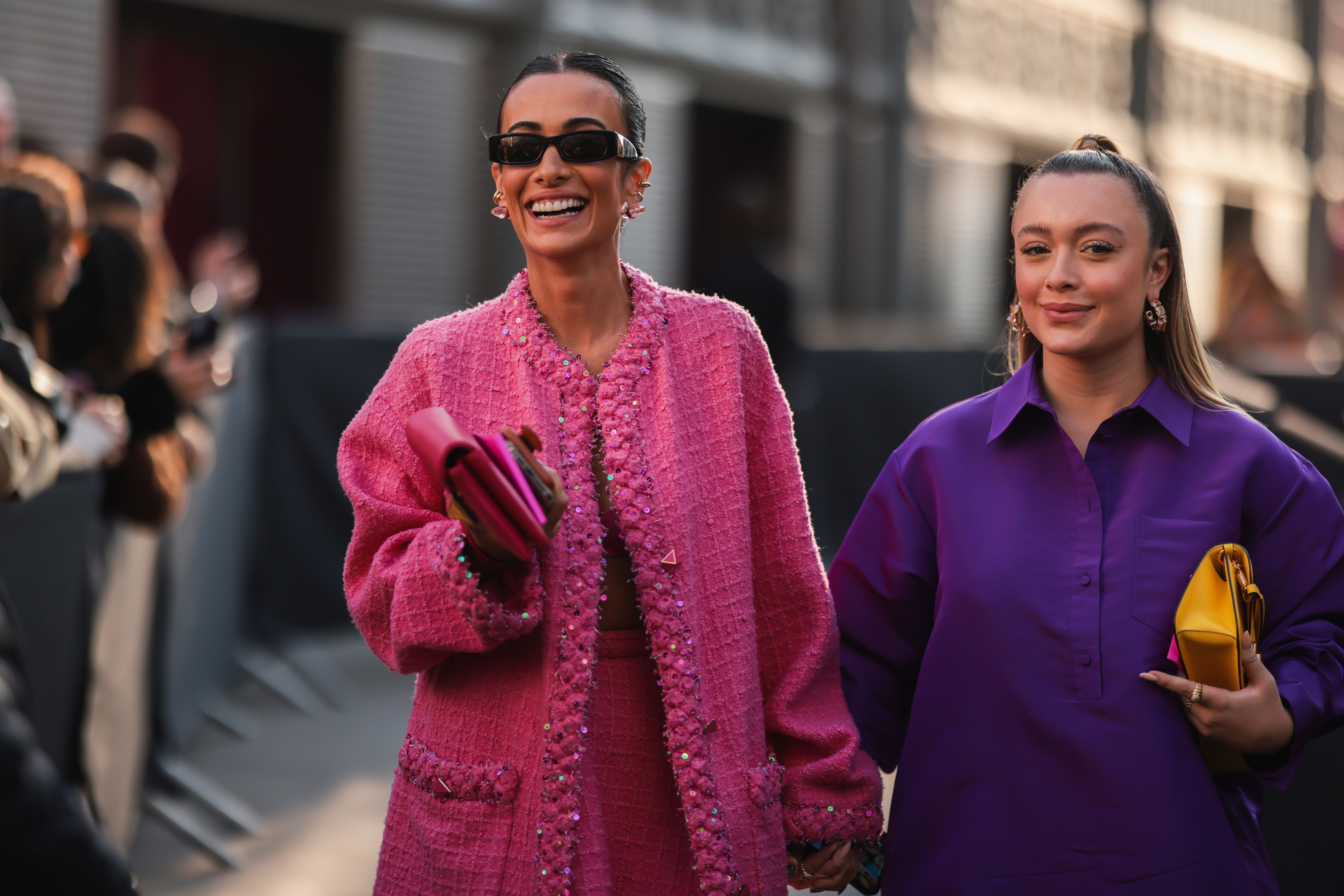 Guests attend a Valentino showing in colour-blocking vivid pink and purple, embellishing the look...